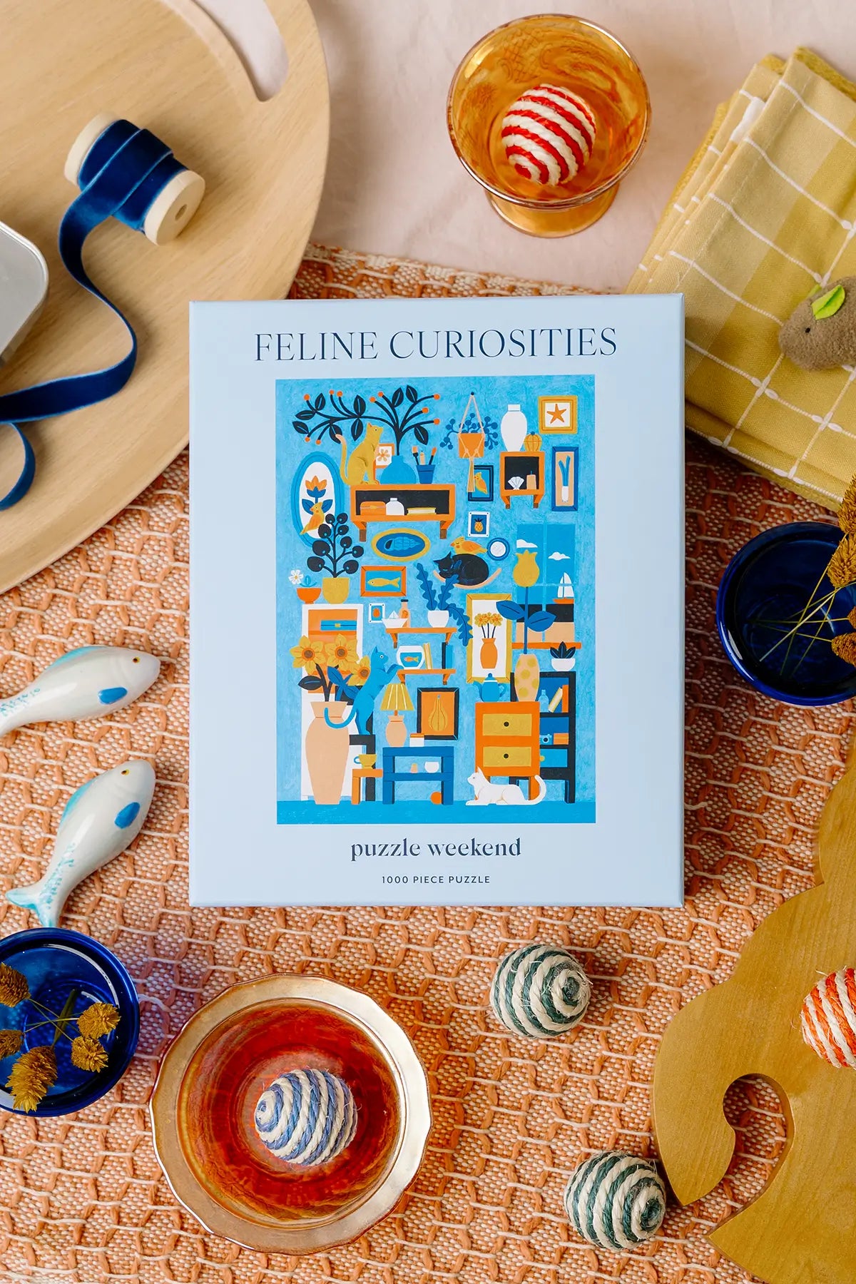 Feline Curiosities puzzle box on a decorative table with tea cups and coasters.