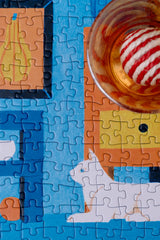 Jigsaw puzzle with a partially completed scene featuring a dog and a cup.