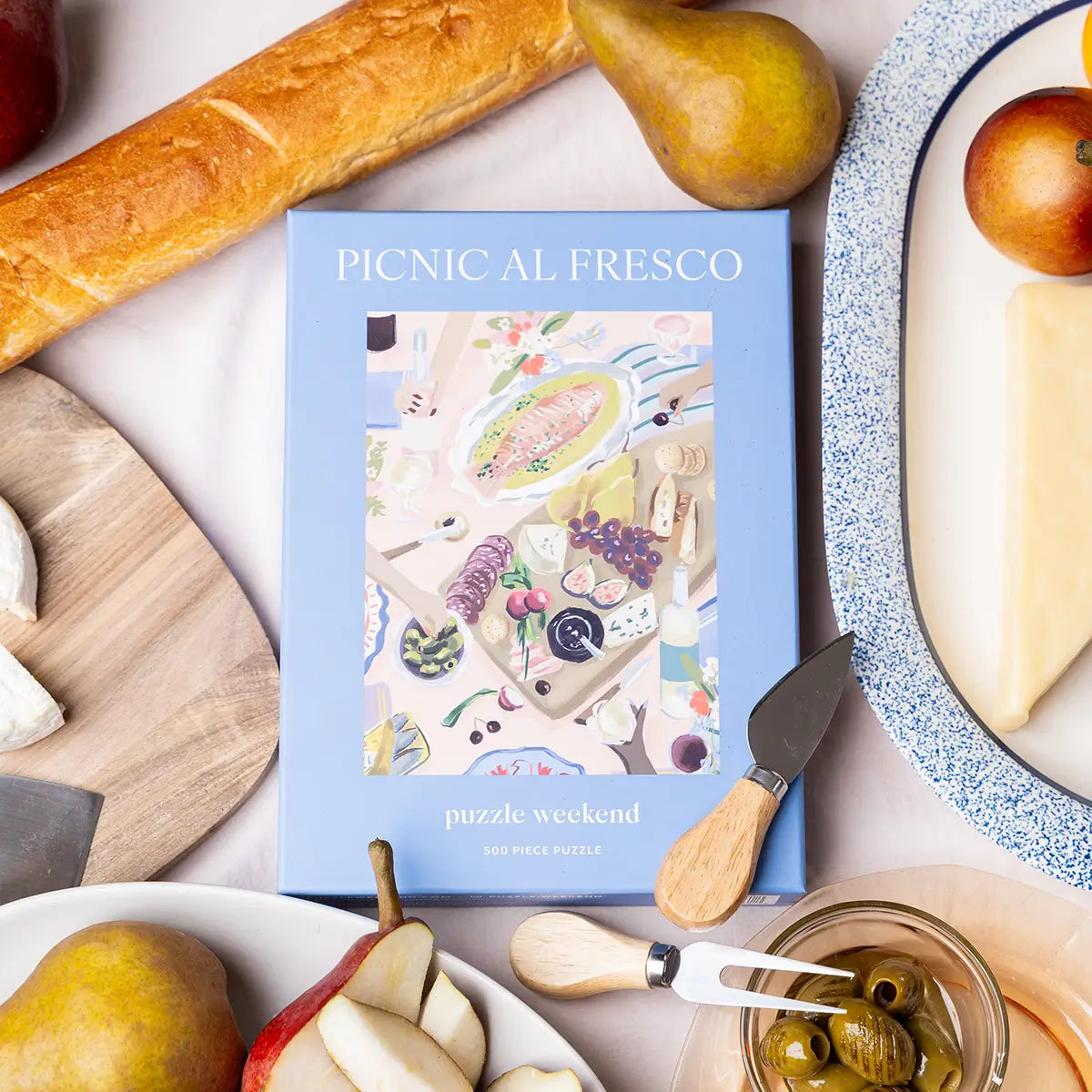 Picnic-themed puzzle packaging with food items on a table