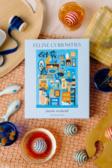 Feline Curiosities puzzle box on a decorative table with tea cups and coasters.